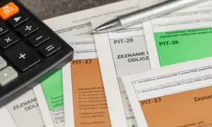 Kalkulator i długopis na dokumentach PIT-37 i PIT-36. Zastanawiasz się, kiedy pit 36, a kiedy 37?