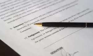Długopis leży na dokumencie, gdzie widnieje nagłówek "umowa użyczenia lokalu" i pole na podpis.