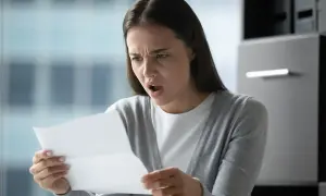 Zaskoczona kobieta czyta dokument. Czy to wypowiedzenie umowy o pracę zgodnie z art. 52 kodeksu pracy?