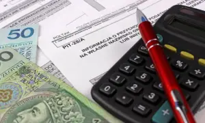 Formularz PIT-28/A, polskie banknoty i kalkulator. Przygotowanie do rozliczenia najmu.