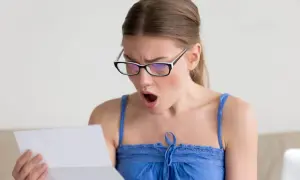 Zaskoczona kobieta w okularach czyta dokument. Czy to wypowiedzenie umowy zlecenia?