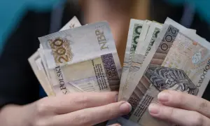 Dłonie trzymające plik banknotów 200 zł. Czy to najwyższa emerytura w Polsce?