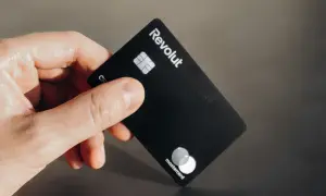 Dłoń trzyma czarną kartę Revolut Business. Nawet jeśli komornik zapuka, płatności Revolutem są bezpieczne.