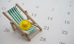 Miniaturowa leżanka z żółtym kapeluszem na kalendarzu. Czy to zapowiedź zmian w kodeksie pracy i urlopu?