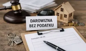 Na stole leży dokument "Darowizna bez podatku", obok młotek sędziowski, klucze do domu, model domu, monety i formularz SD-Z2.