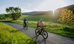 Dwie osoby na rowerach elektrycznych cieszą się malowniczą trasą. Dofinansowanie do roweru elektrycznego ułatwia takie wycieczki.