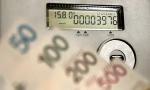 Licznik energii pokazuje zużycie 3976 kWh. W tle rozmazane banknoty 50, 100, 200, 500 zł, sugerujące wysoką cenę za kWh.