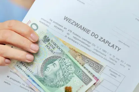 Dłoń trzyma banknoty 100 i 200 zł na wezwaniu do zapłaty. Zastanawiasz się, ile zarabia komornik?