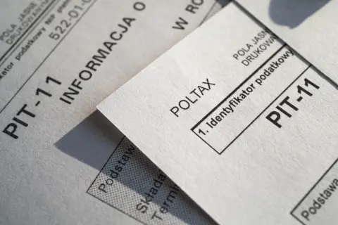 Dokumenty PIT-11 i Poltax, kluczowe dla rezydenta podatkowego, leżą obok siebie.