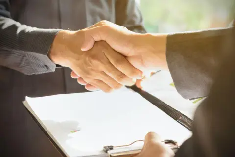 Uścisk dłoni po podpisaniu umowy, która może dotyczyć prawa pierwokupu.
