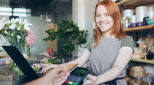 Uśmiechnięta sprzedawczyni w kwiaciarni obsługuje płatność kartą. Paragon z nipem do jakiej kwoty?