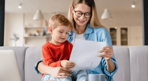 Mama z synkiem aktywnie w domu dla kogoś, przeglądają dokumenty.