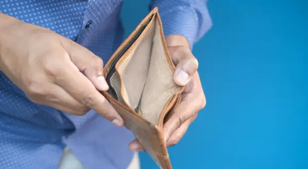 Puste, brązowe etui na karty, trzymane w dłoniach, symbolizuje bankructwo i brak środków.