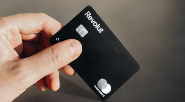 Dłoń trzyma czarną kartę Revolut Business. Nawet jeśli komornik zapuka, płatności Revolutem są bezpieczne.