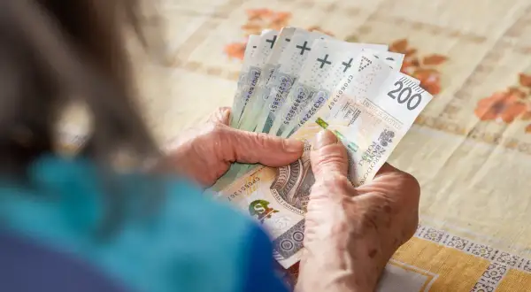 Dłonie liczą banknoty 200 zł. Może to być pomoc w ramach zasiłku celowego na pokrycie pilnych potrzeb.