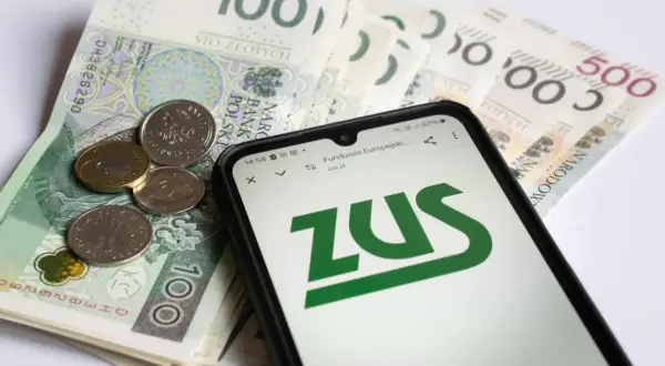 Złotówki i monety obok telefonu z logo ZUS. Może to być związane z mops zasiłek pielęgnacyjny.