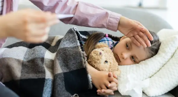 Chora dziewczynka z misiem, mama sprawdza temperaturę. Wniosek z15a.
