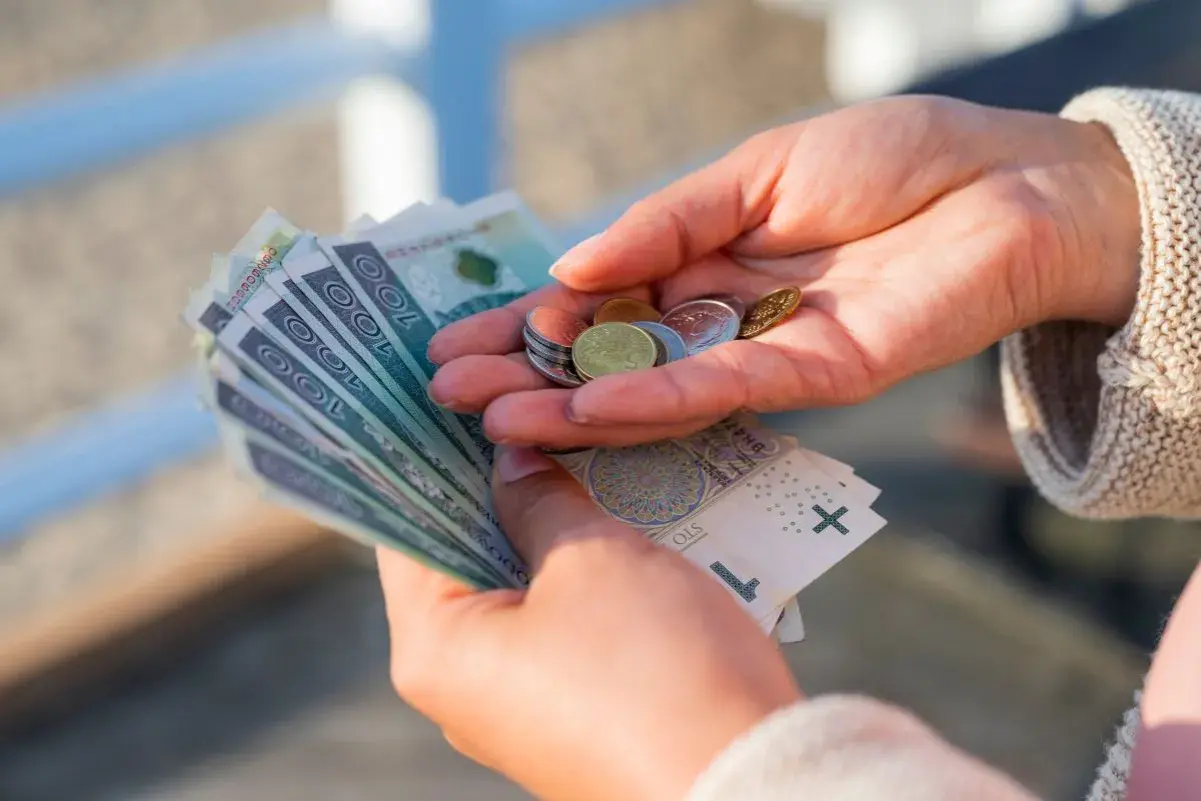 Dłonie liczą banknoty i monety. Zastanawiasz się, ile to netto z 3/4 etatu?