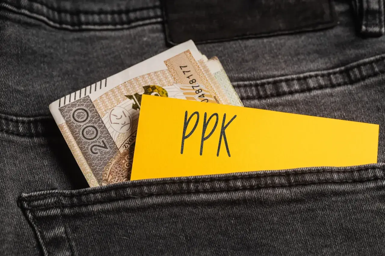 Złotówki w tylnej kieszeni dżinsów, obok żółtej kartki z napisem "PPK". Decyzja o rezygnacji z PPK.