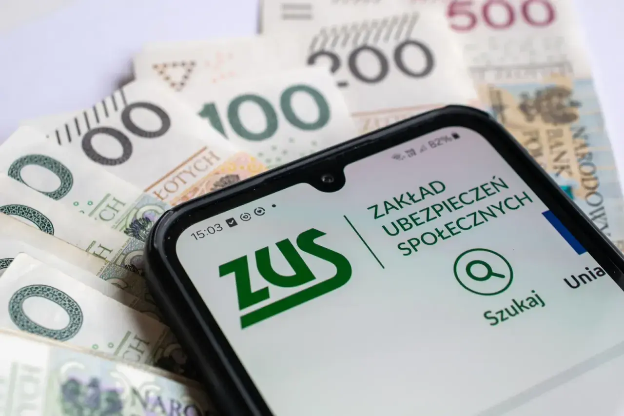 Telefon z aplikacją ZUS na tle polskich banknotów. Sprawdzanie informacji o 13 emeryturze 2026 w tabeli.
