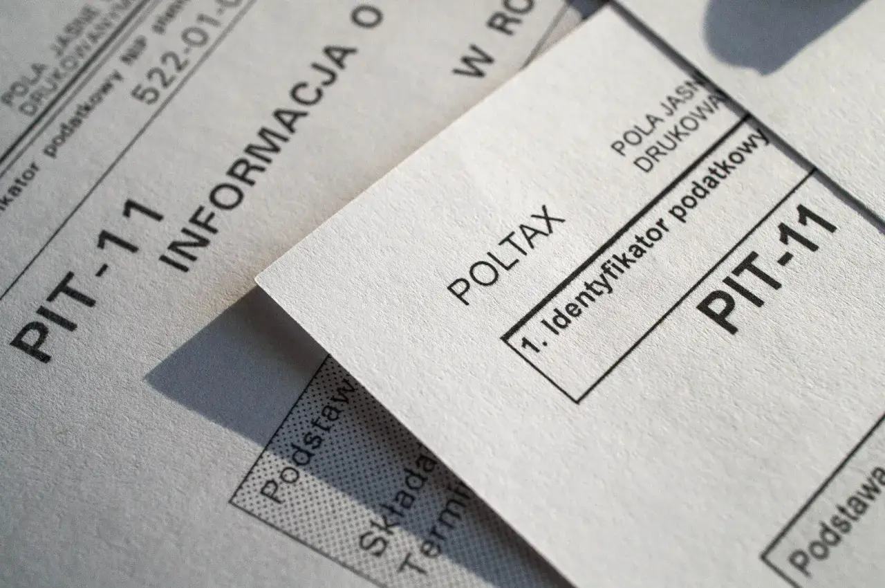 Dokumenty PIT-11 i Poltax, kluczowe dla rezydenta podatkowego, leżą obok siebie.