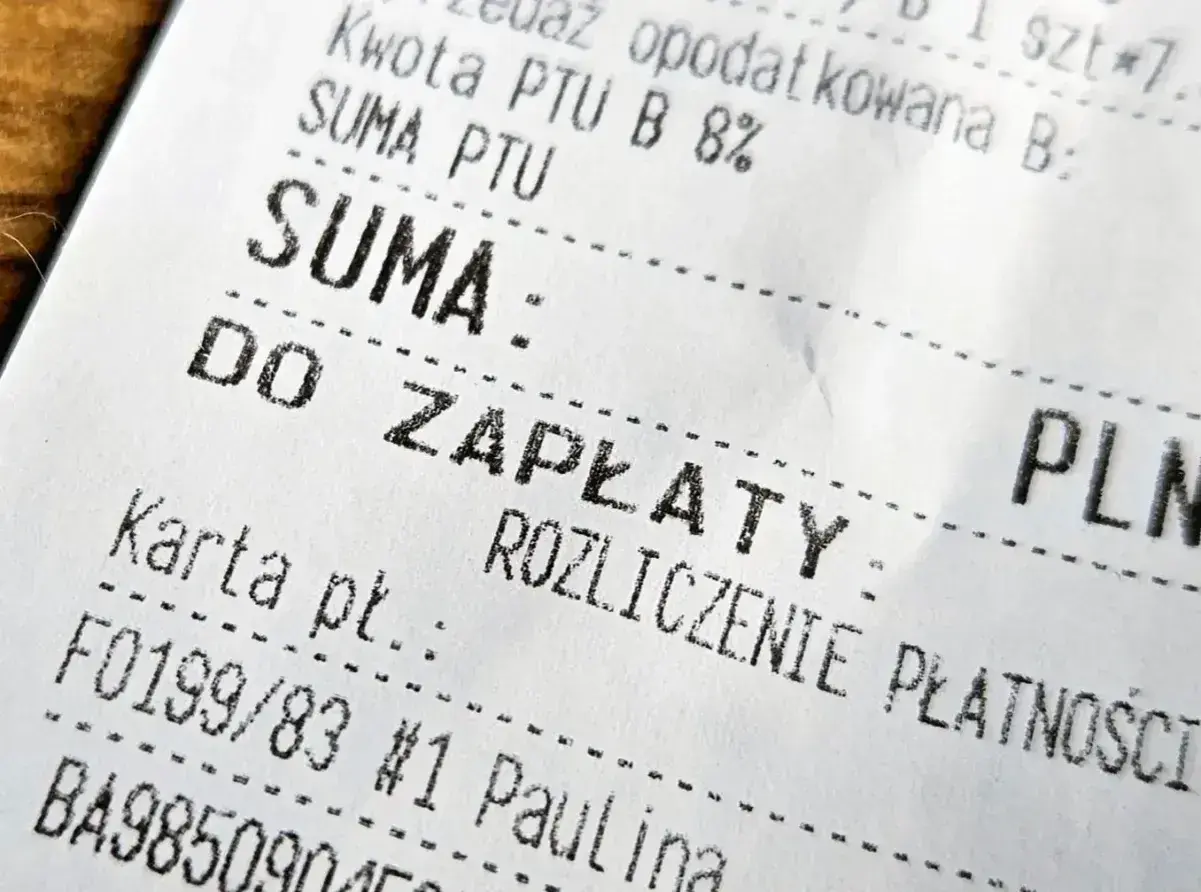 Fragment paragonu z napisem "DO ZAPŁATY". Widoczne są też dane do faktury, takie jak "SUMA" i "PLN".