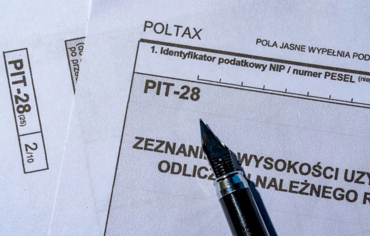Formularz PIT-28, gotowy do wypełnienia. Zeznanie podatkowe za najem, z piórem czekającym na wpisanie danych.