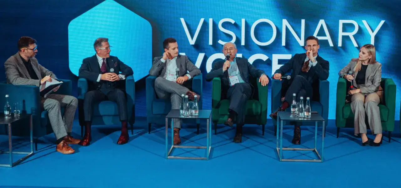 Panel dyskusyjny o fundacji rodzinnej: co to jest i jak działa. Uczestnicy w eleganckich strojach siedzą na fotelach przed ekranem z napisem