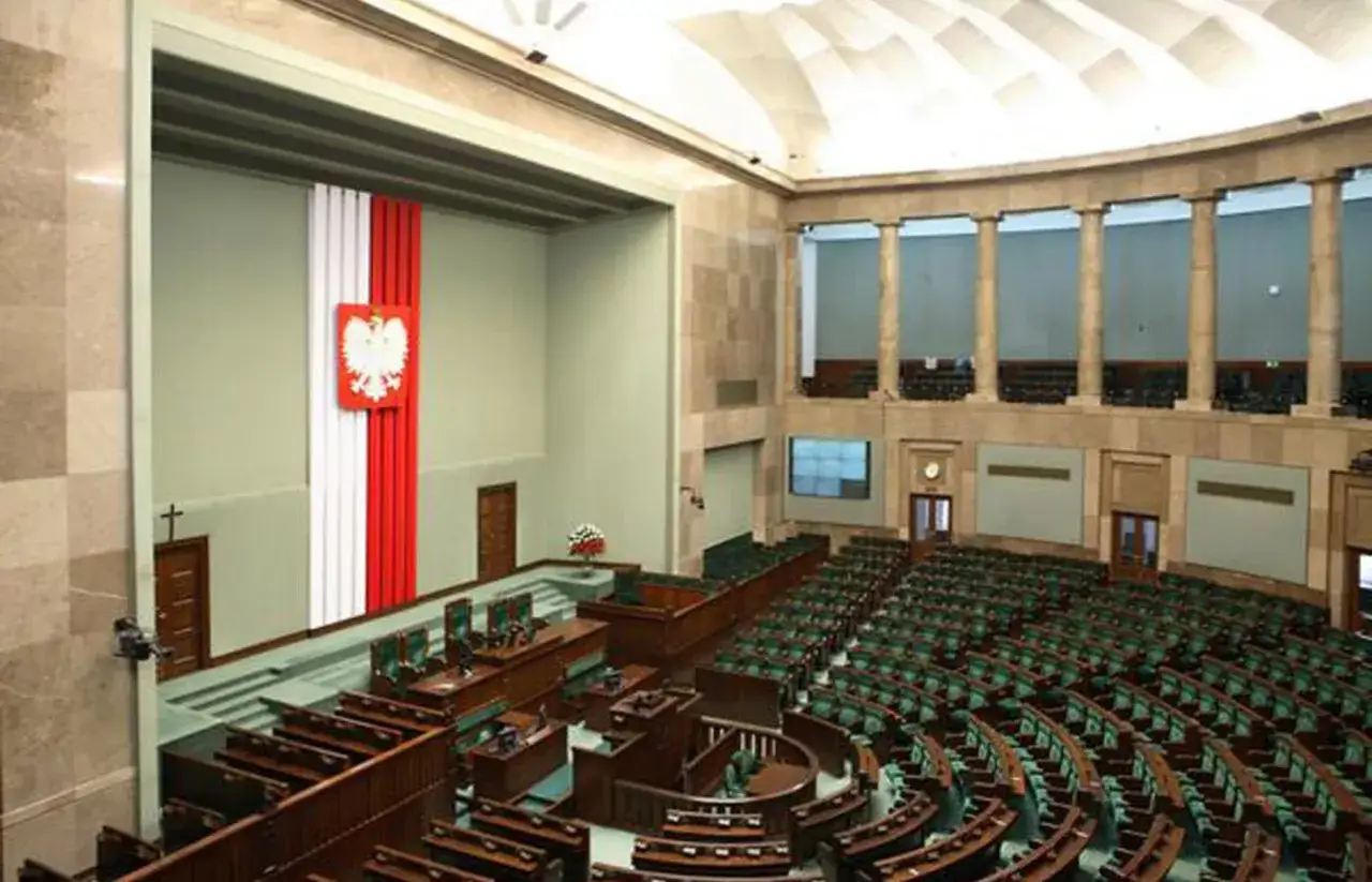 Sala plenarna Sejmu RP z godłem i flagą. Tu dyskutuje się, ile wynosi dieta poselska.