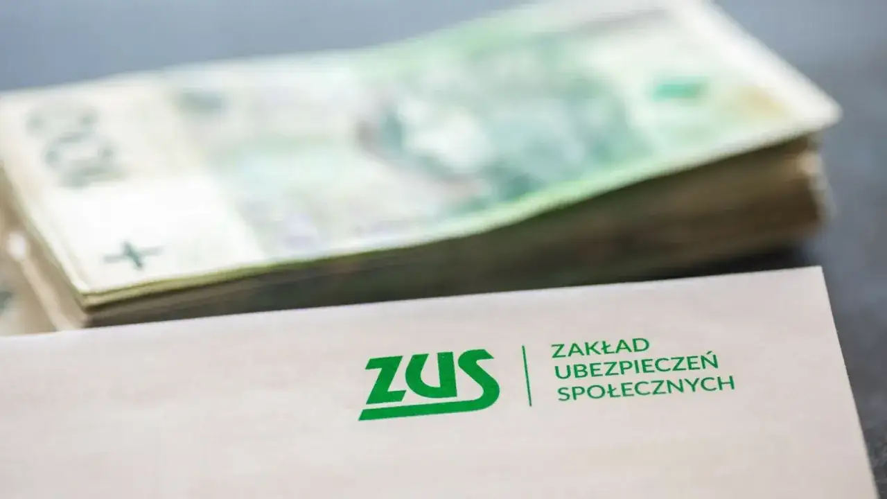 Koperta z logo ZUS i stos banknotów. Finanse spółki partnerskiej i zobowiązania wobec ZUS.