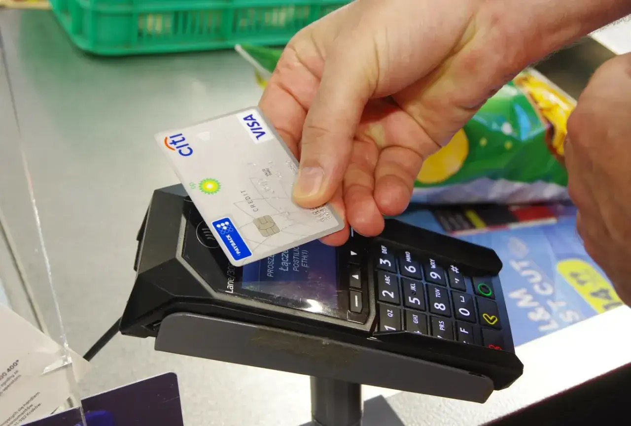 Karta debetowa zbliżeniowa Visa Citi BP zbliżana do terminala płatniczego. Szybka płatność bez PIN-u.