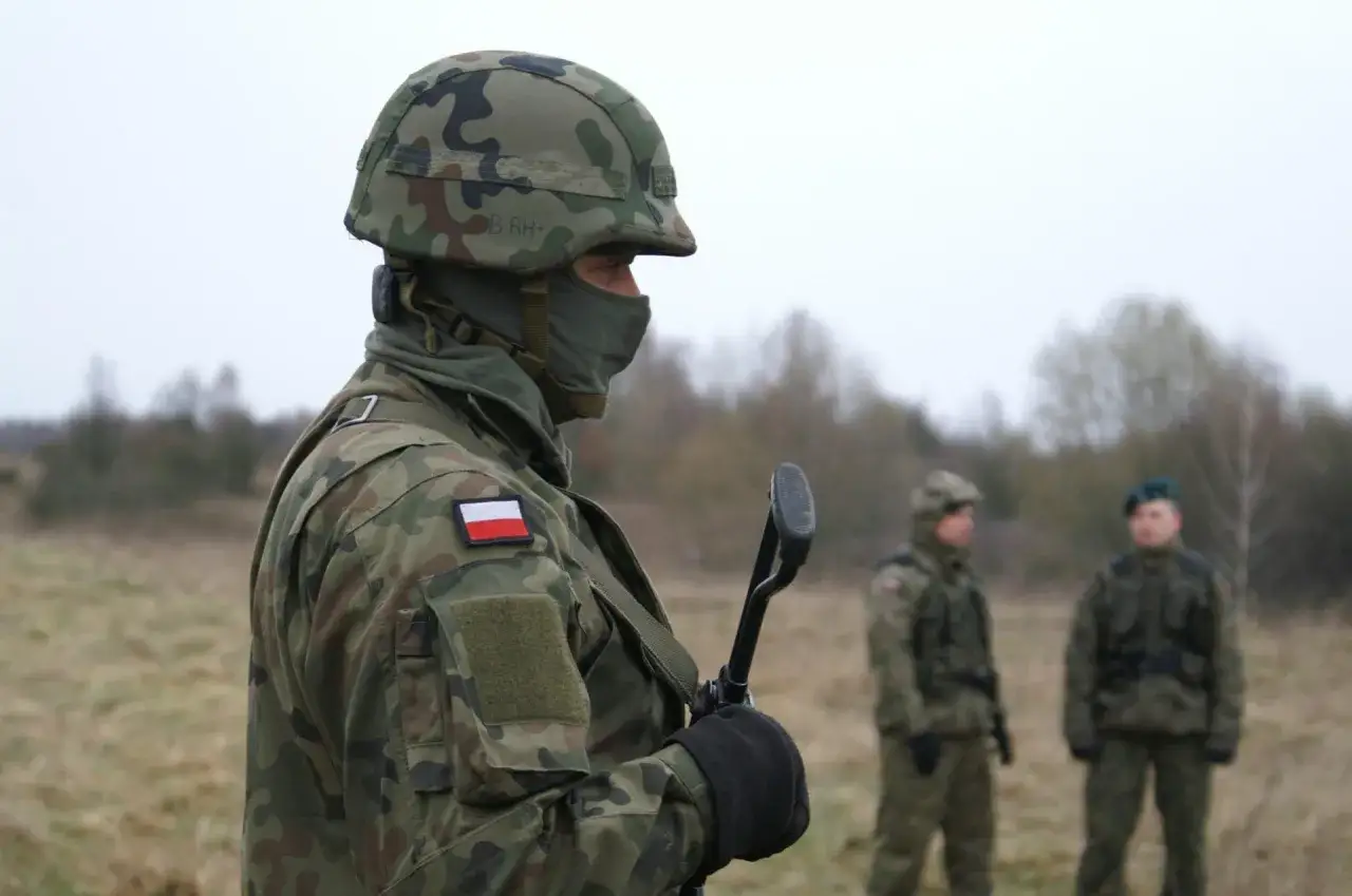 Żołnierz w kamuflażu, z polską flagą na ramieniu, trzyma broń. Zastanawiasz się, ile zarabia żołnierz netto?