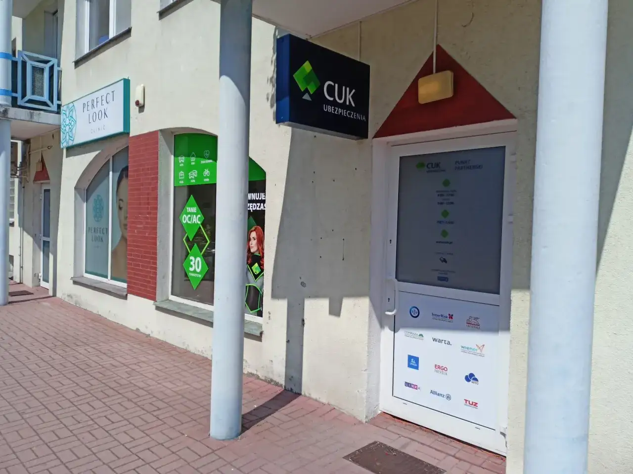 Elewacja budynku z szyldami CUK Ubezpieczenia i Perfect Look Clinic.
