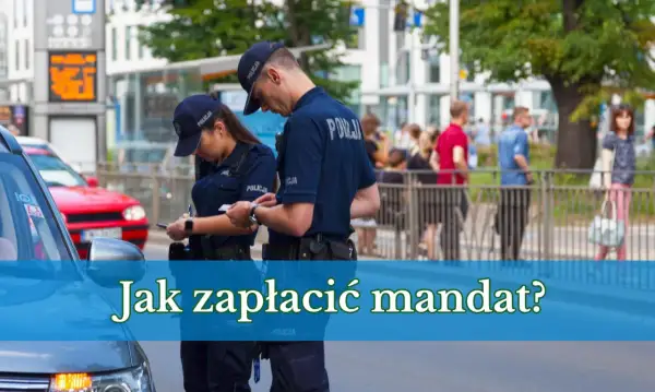 Dwóch policjantów w mundurach dyskutuje, jak zapłacić mandat przelewem. W tle ludzie i budynki.