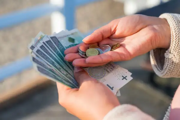 Dłonie liczą banknoty i monety. Zastanawiasz się, ile to netto z 3/4 etatu?