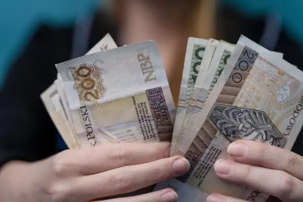 Dłonie trzymające plik banknotów 200 zł. Czy to najwyższa emerytura w Polsce?