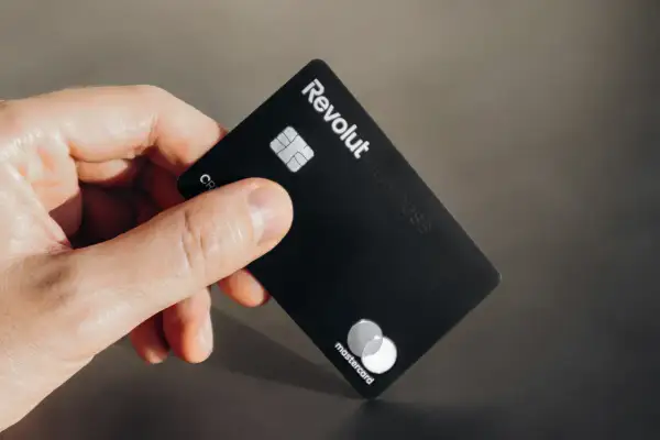 Dłoń trzyma czarną kartę Revolut Business. Nawet jeśli komornik zapuka, płatności Revolutem są bezpieczne.