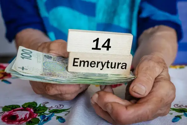 Dłonie trzymają stos banknotów i drewniane klocki z napisami "14" i "Emerytura". Kiedy będą wypłacane czternastki?