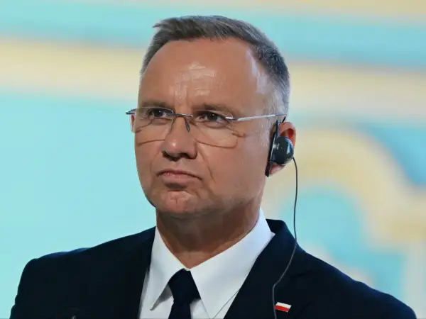 Prezydent w okularach i słuchawkach, z wpiętą flagą Polski. Czy myśli o przyszłej emeryturze prezydenckiej?